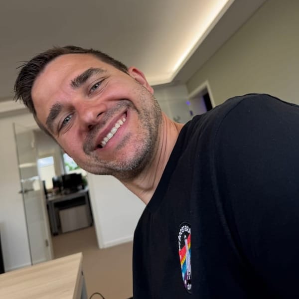 Markus Mazur, Geschäftsführer von dxm, lächelt in die Kamera. Im Hintergrund ein modernes Büro mit indirekter Deckenbeleuchtung.